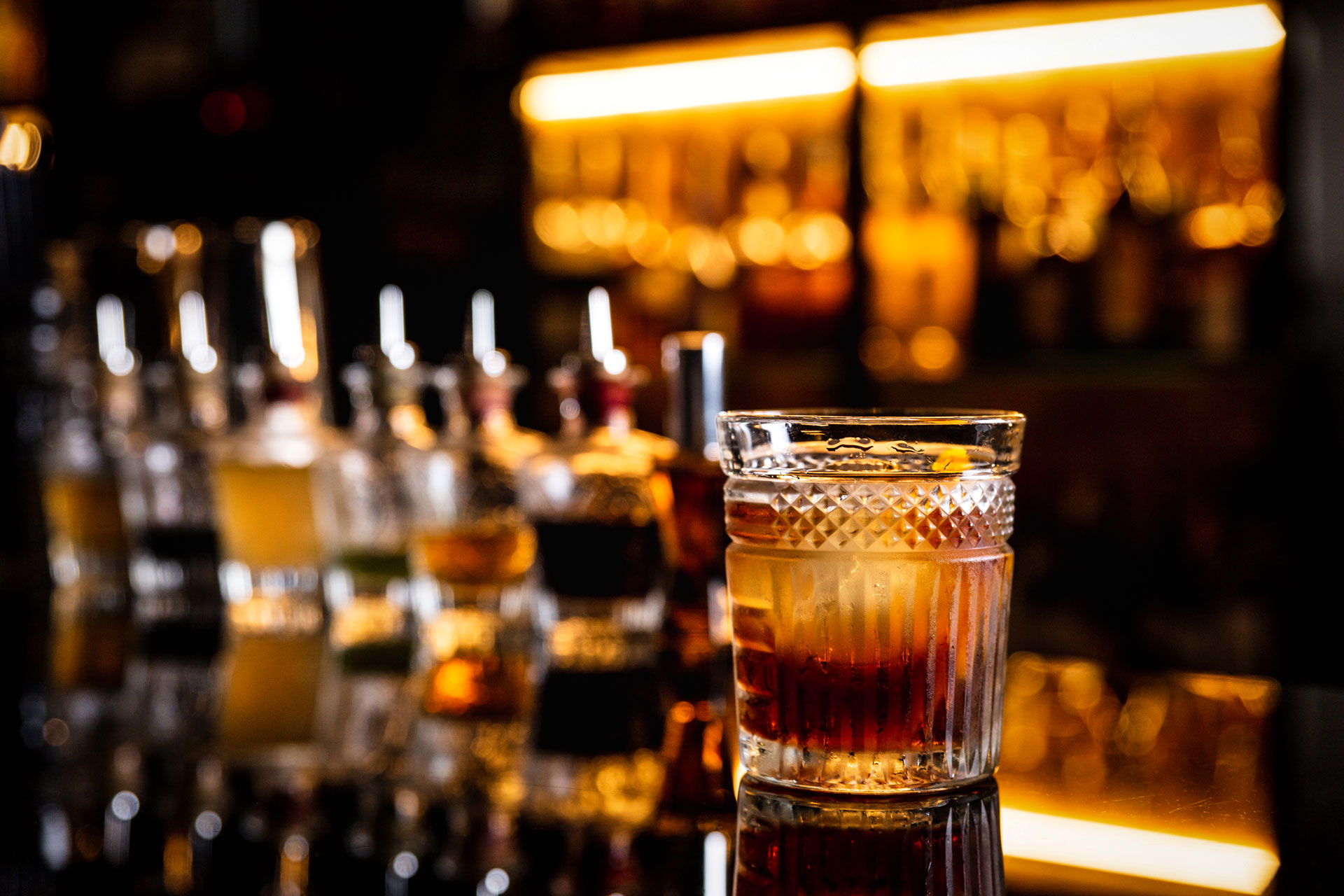 a cocktail in an old fashioned glass on a bar coun