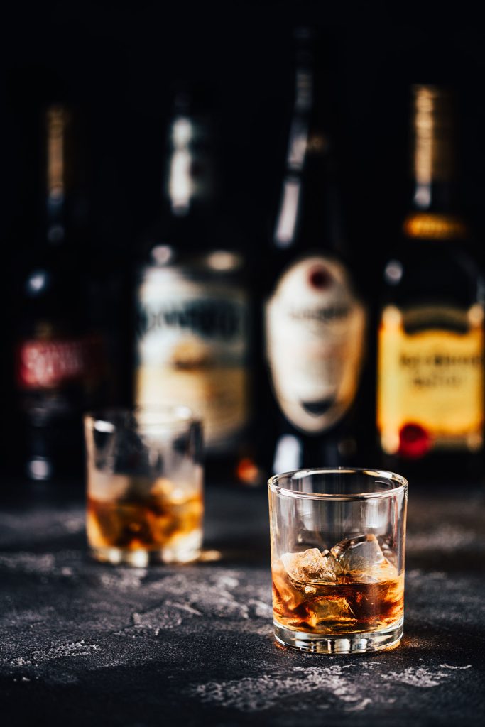 whiskey with ice on a dark table
